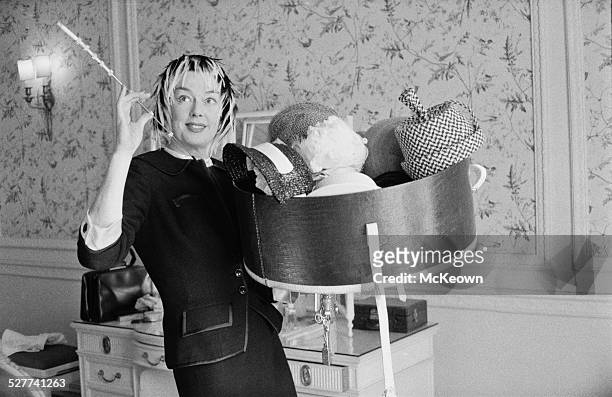 American actress Rosalind Russell holding a collection of hats, 22nd August 1958.
