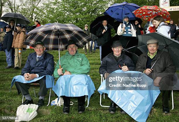Spectators attempt to shelter from the rain during the German Jumping and Dressage Grand Prix at the Derby Park Hamburg Klein Flottbek on May 8, 2005...