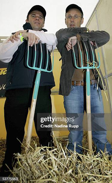 The CEO of the Hamburger SV Bernd Hoffmann and Reinhold Beckmann clean out a stable during German Jumping and Dressage Grand Prix at the Derby Park...