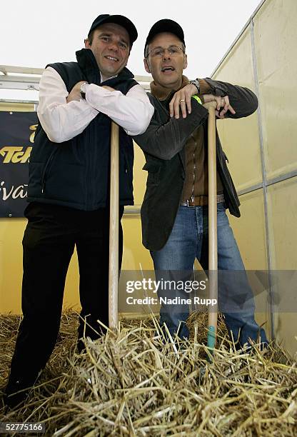 The CEO of the Hamburger SV Bernd Hoffmann and Reinhold Beckmann clean out a stable during German Jumping and Dressage Grand Prix at the Derby Park...