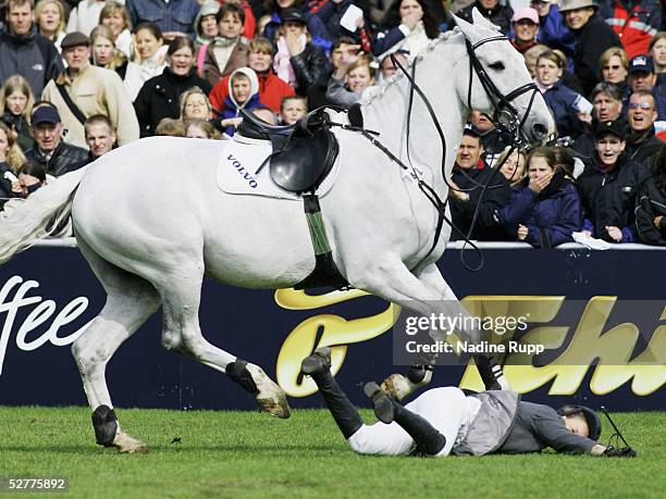 Janne-Friederike Meyer of germany falls from her horse Callistro at the Tschibo Wall during the 76. German Jumping-Derby 2005 of the German Jumping...