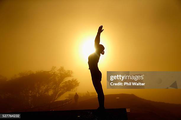 Lady practices yoga on the summit of Mt Eden as the sun struggles to shine through a blanket of fog over Auckland City on May 4, 2016 in Auckland,...