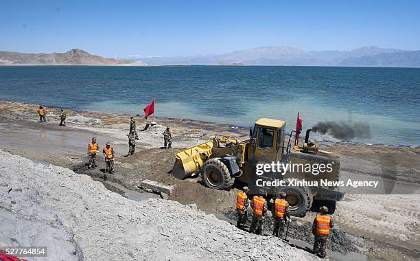 May 3, 2016 -- File photo taken on May 3, 2011 shows workers repairing a section of the Xinjiang-Tibet Highway along the Bangong Lake in northwest...