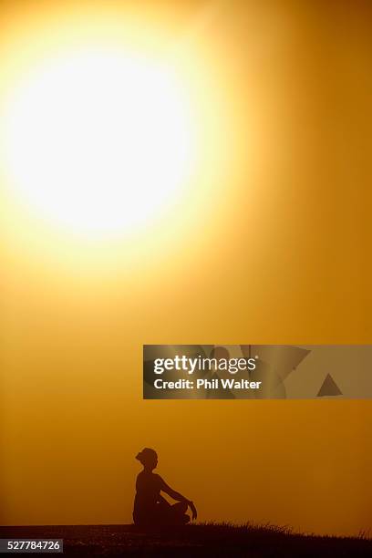 Lady practices yoga on the summit of Mt Eden as the sun struggles to shine through a blanket of fog over Auckland City on May 4, 2016 in Auckland,...