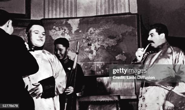 Russian leader Joseph Stalin and Russian military commander Kliment Voroshilov smoking pipes in oriental dress, 1939.