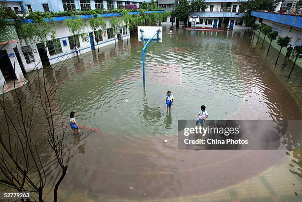 Students play at the flooded playground after heavy rain at a primary school May 9, 2005 in Guangzhou of Guangdong Province, China. Continuous...