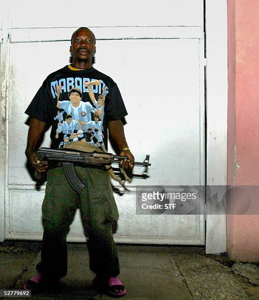 Congolese soldier wearing a Maradona t-shirt and carrying an AKM assault rifle keeps watch 09 May, 2005 at the residence of a Congolese Army Colonel...