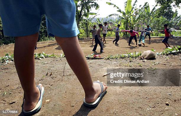 Child watches his friends play football May 9, 2005 at Girijaya village, Sukabumi, Indonesia. Indonesian health authorities confirmed on May 6 that...