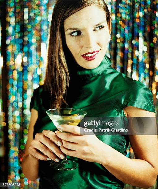 woman holding martini at party - robe de cocktail photos et images de collection