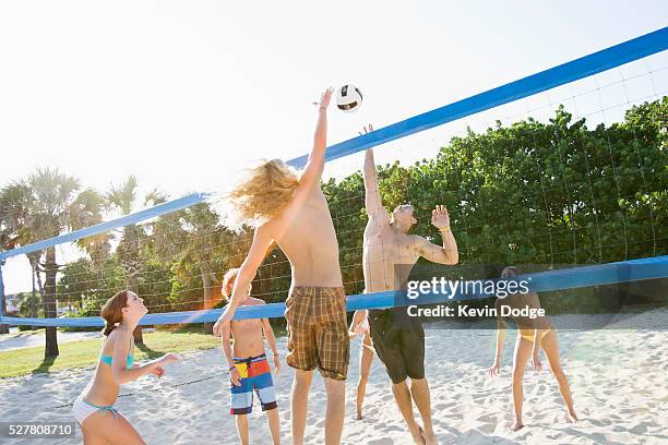 teenagers playing beach volleyball - girls beach volleyball stock pictures, royalty-free photos & images