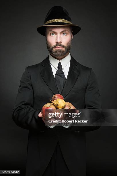 man in traditional outfit holding fruits - apples and pears stock-fotos und bilder