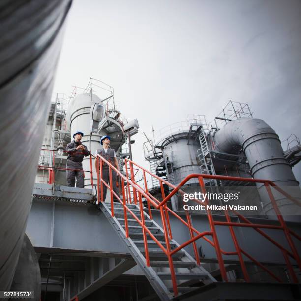 workers on refinery walkway - refinery stock pictures, royalty-free photos & images