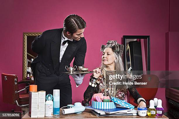 woman wearing curlers, butler in background - hair rollers stock pictures, royalty-free photos & images