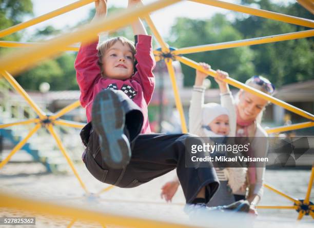 mother with 2 children on playground - kinderspielplatz stock-fotos und bilder