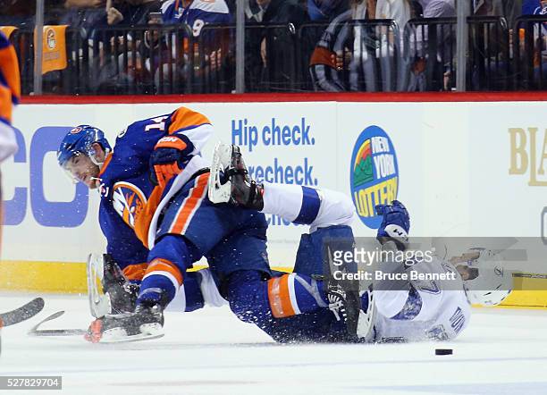 Thomas Hickey of the New York Islanders checks Jonathan Drouin of the Tampa Bay Lightning during the second period in Game Three of the Eastern...