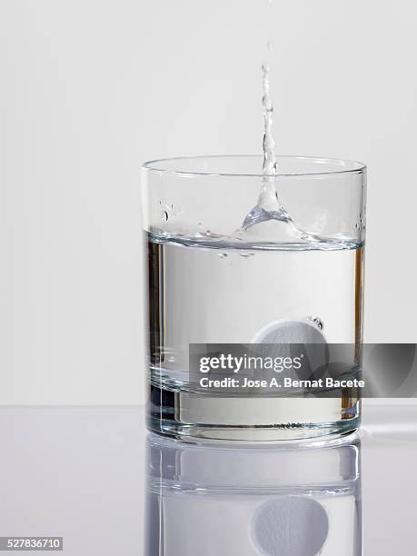tablet of effervescent medicine falling down inside a water glass - carbonated stock pictures, royalty-free photos & images