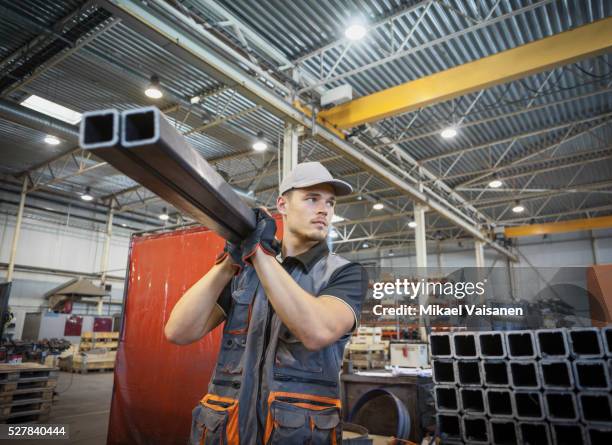 young industrial worker in steel processing factory - industriearbeiter stock-fotos und bilder