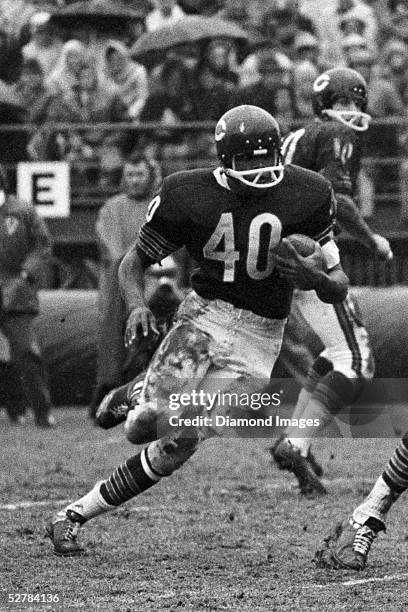 Runningback Gale Sayers#40 of the Chicago Bears looks for running room during a game on November 27, 1966 against the Atlanta Falcons in Chicago,...