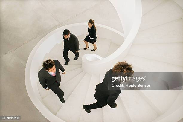 businesspeople climbing spiral staircase - spiral staircase stock pictures, royalty-free photos & images