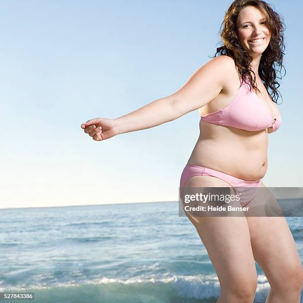 woman dancing on beach - fat woman dancing stockfoto's en -beelden