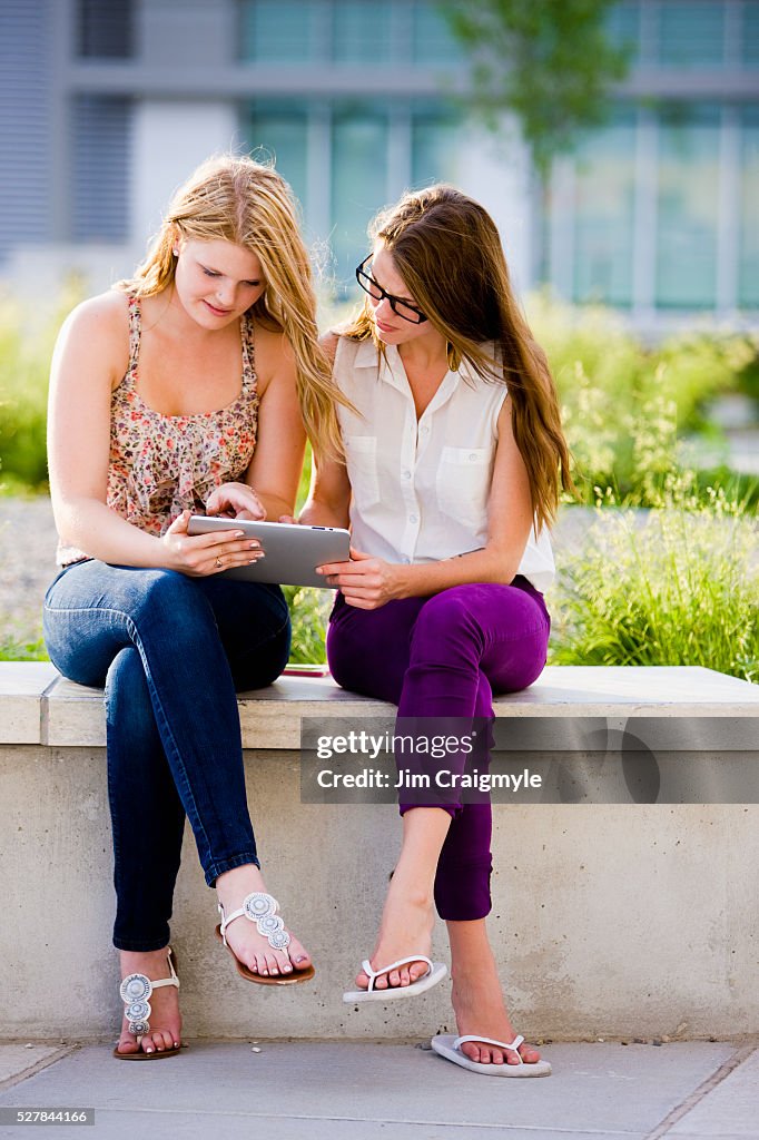 Two Friends Using A Computer Two Friends Using Tablet Pc High-Res Stock Photo - Getty Images
