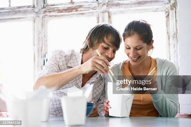 couple sharing chinese takeout - chinese takeout stock pictures, royalty-free photos & images
