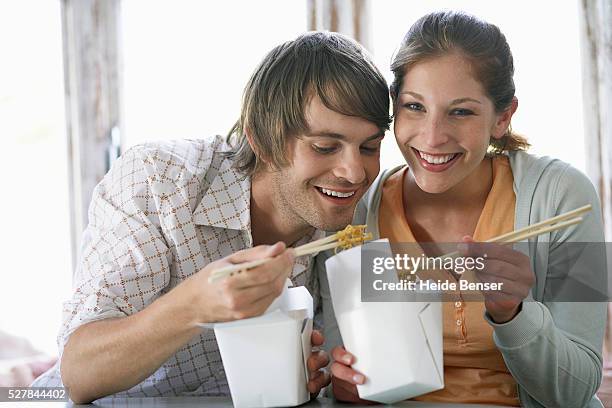 couple sharing chinese takeout - chinese takeout stock pictures, royalty-free photos & images