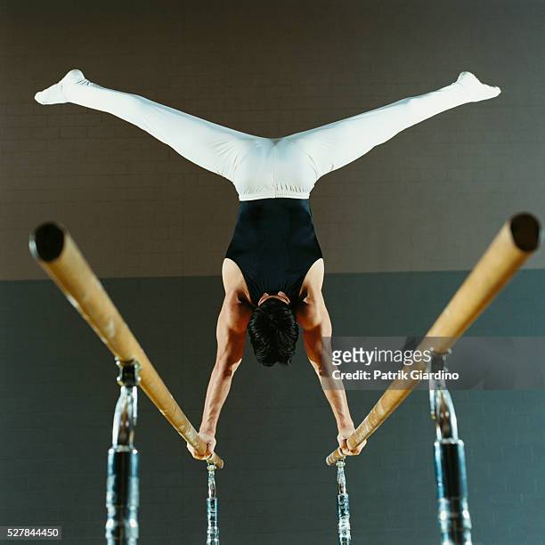 gymnast balancing on parallel bars - barras paralelas barra de ginástica - fotografias e filmes do acervo