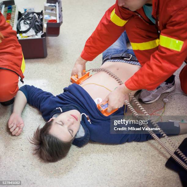 paramedics helping patient - defibrillation stock-fotos und bilder