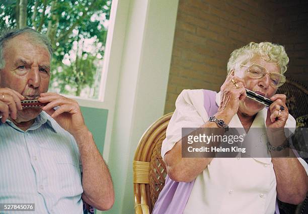 senior couple playing harmonicas - harmonica stock pictures, royalty-free photos & images