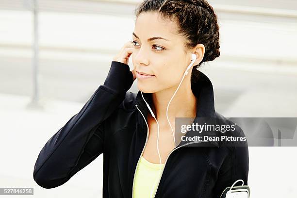 woman (21-30 year old) listening to music outdoors - pale complexion stock-fotos und bilder