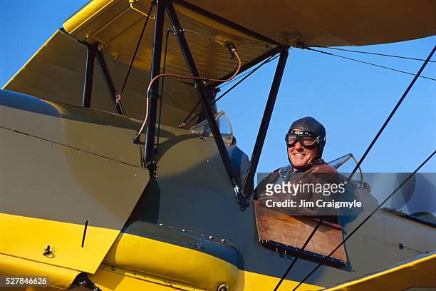senior man piloting 1937 tiger moth - fliegermütze stock-fotos und bilder