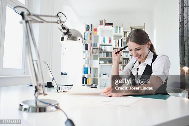 businesswoman sitting at desk in office - archival office stock pictures, royalty-free photos & images