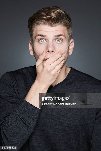 shocked young man - hands covering mouth stockfoto's en -beelden