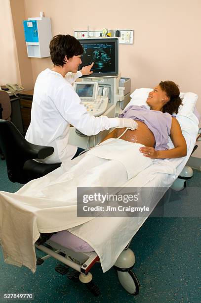 pregnant woman getting ultrasound - twin ultrasound stock pictures, royalty-free photos & images