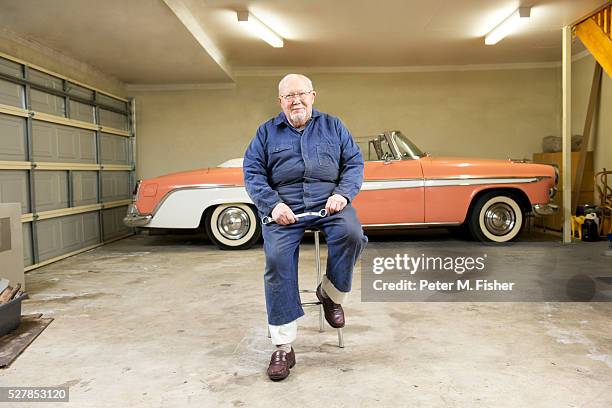 portrait of senior man with classic vintage car in garage - voiture de collection photos et images de collection