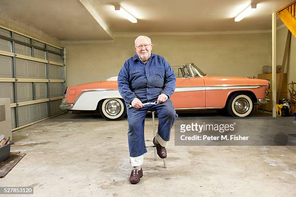 portrait of senior man with classic vintage car in garage - 車　作業員 ストックフォトと画像
