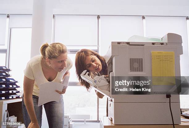 businesswomen working on copier - kopiergerät stock-fotos und bilder