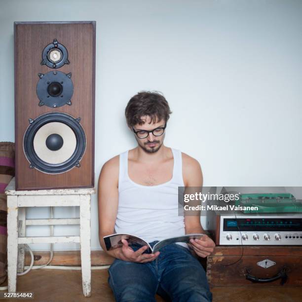 man reading magazine - equipo de alta fidelidad fotografías e imágenes de stock