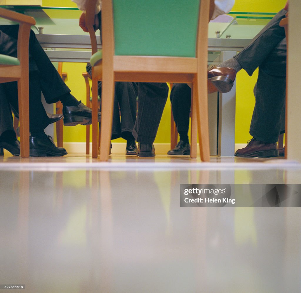 Businesspeople's Legs Under Table
