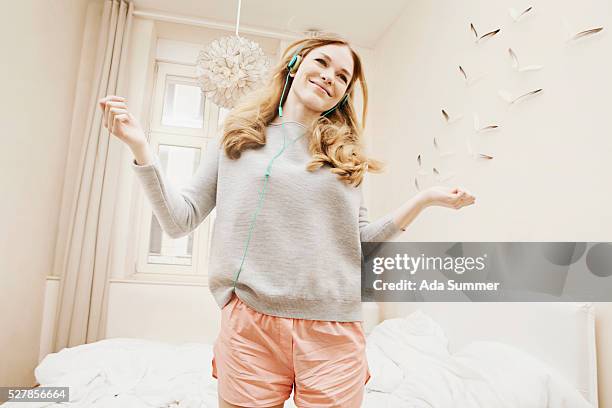 young girl wearing headphones and dancing in her room - teenager dream work bildbanksfoton och bilder