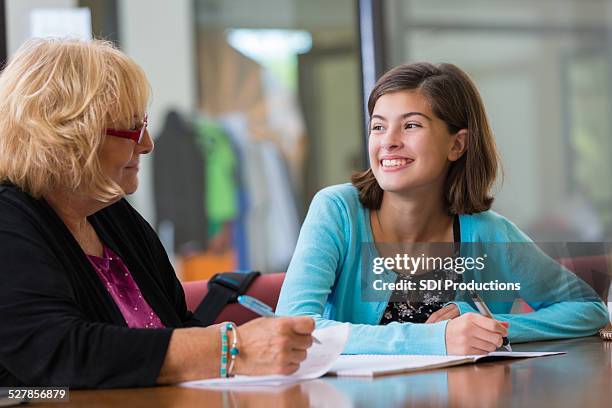 tutor explaining homework assignment to preteen student - child psychologist stock pictures, royalty-free photos & images