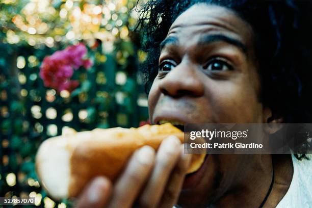 man eating hot dog - avidità foto e immagini stock