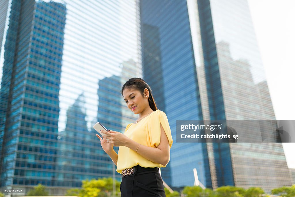 Asian woman reading text messages at outdoor