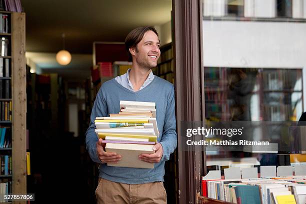 student carrying stack of books - man holding book fotografías e imágenes de stock