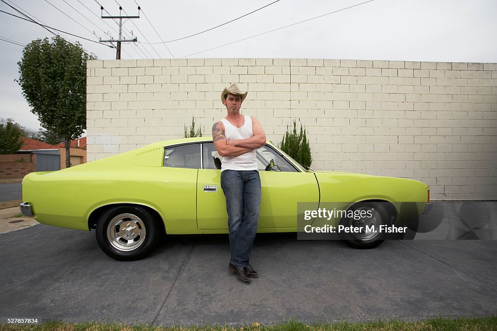 Man with Cowboy Hat Leaning on Muscle Car