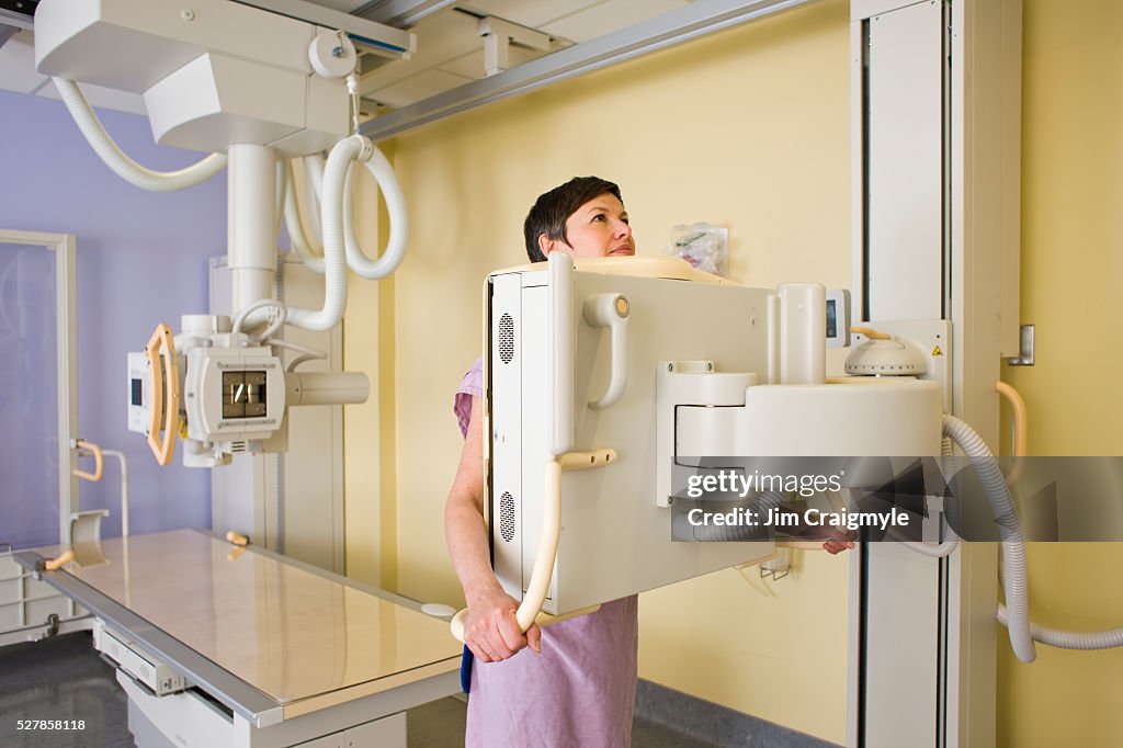 Woman having upright posterior-anterior view of her chest using digital diagnose general radiography machine