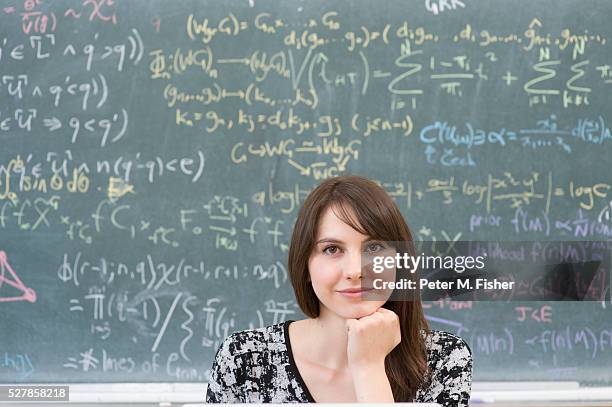 portrait of teenage girl (16-17 years) by blackboard - mathematical symbol stock photos et images de collection