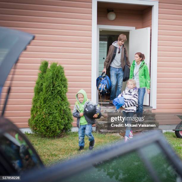 family with boy and girl (5-6, 7-9) leaving house for camping - four people walking away stock pictures, royalty-free photos & images