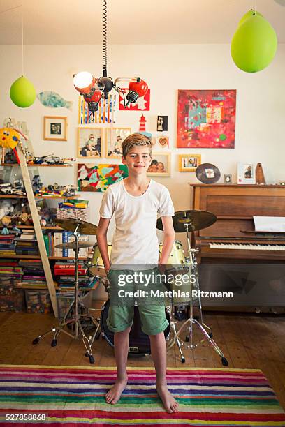 adolescent boy (13-15) in front of drums - teen boy shorts stock-fotos und bilder